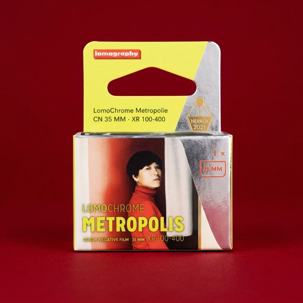 LomoChrome Metropolis 35mm film box, yellow and silver packaging, on red background