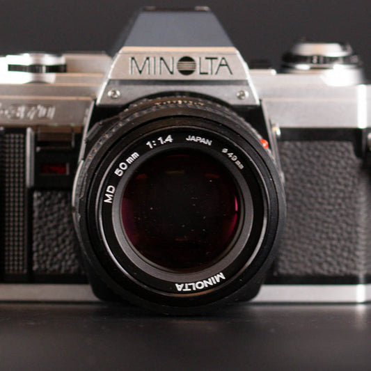 Minolta camera with lens on a dark background