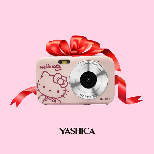 Hello Kitty camera with a red ribbon on a pink background, featuring the Yashica brand.