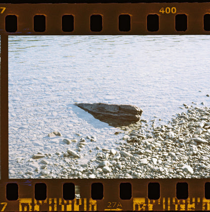Close-up of a rocky beach with a film strip border
