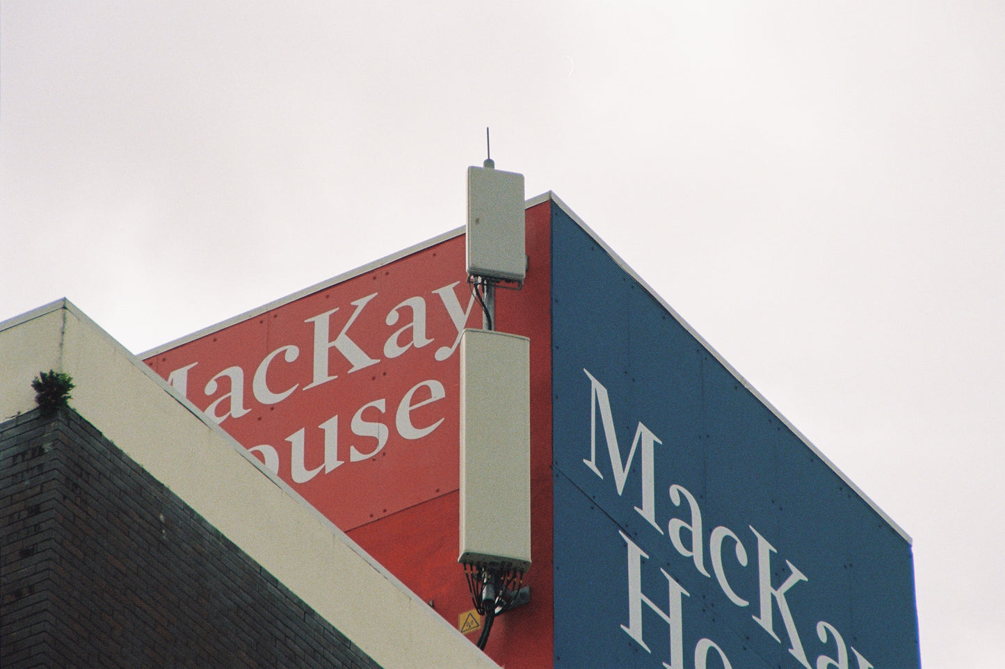 MacKay House sign on a building with a cloudy sky background