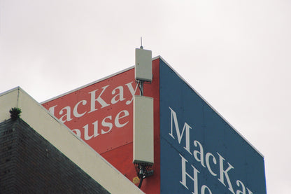 MacKay House sign on a building with a cloudy sky background