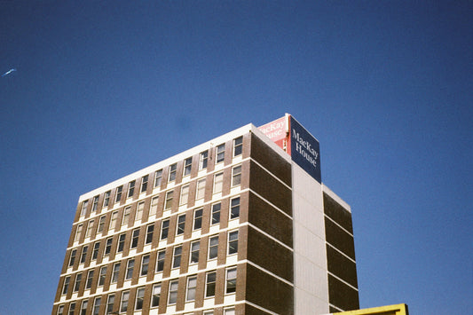 Sample shot: brick office tower with MacKay House rooftop sign against a deep blue sky