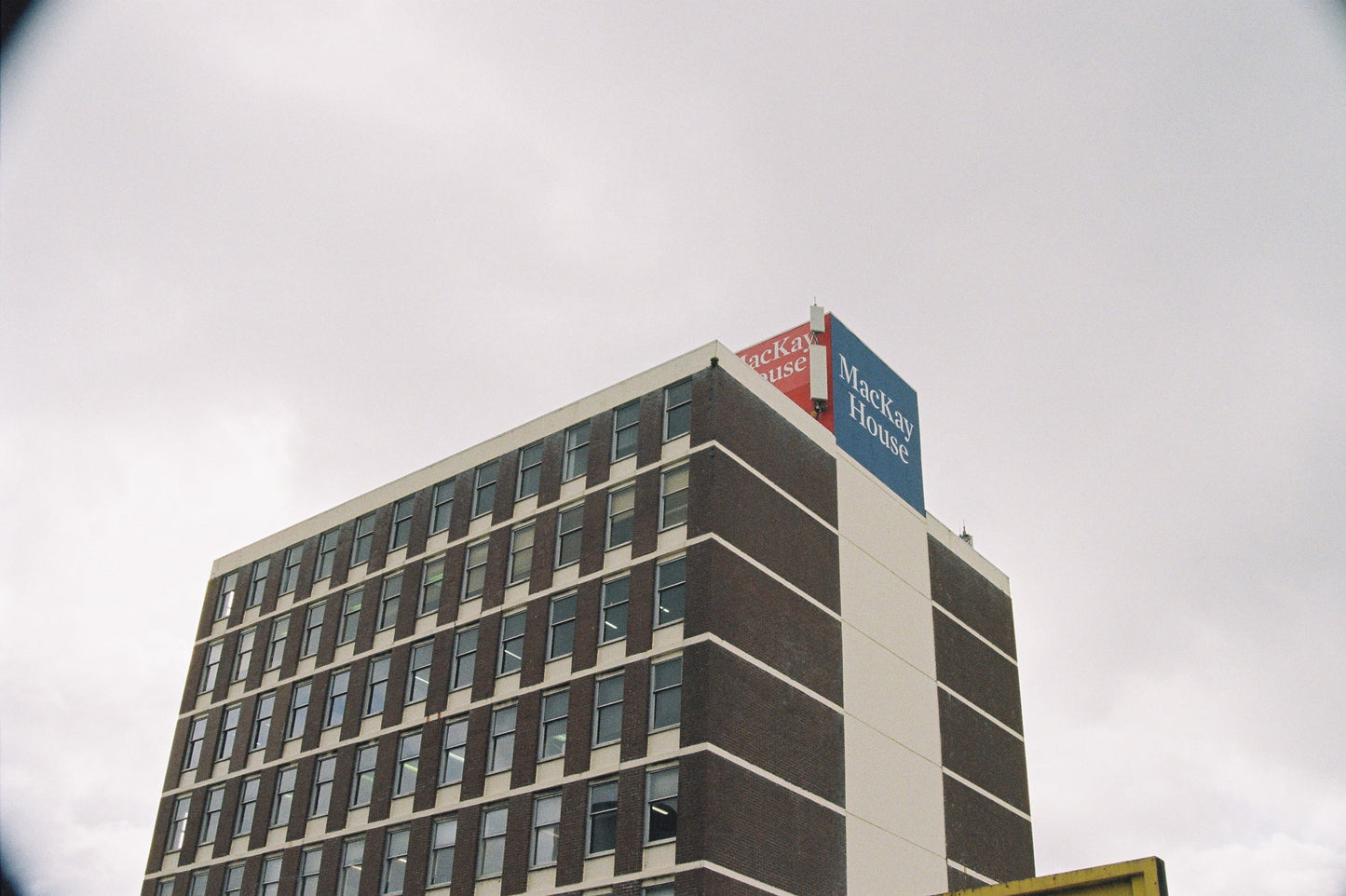 High-rise building with a Mackay House sign on a cloudy day