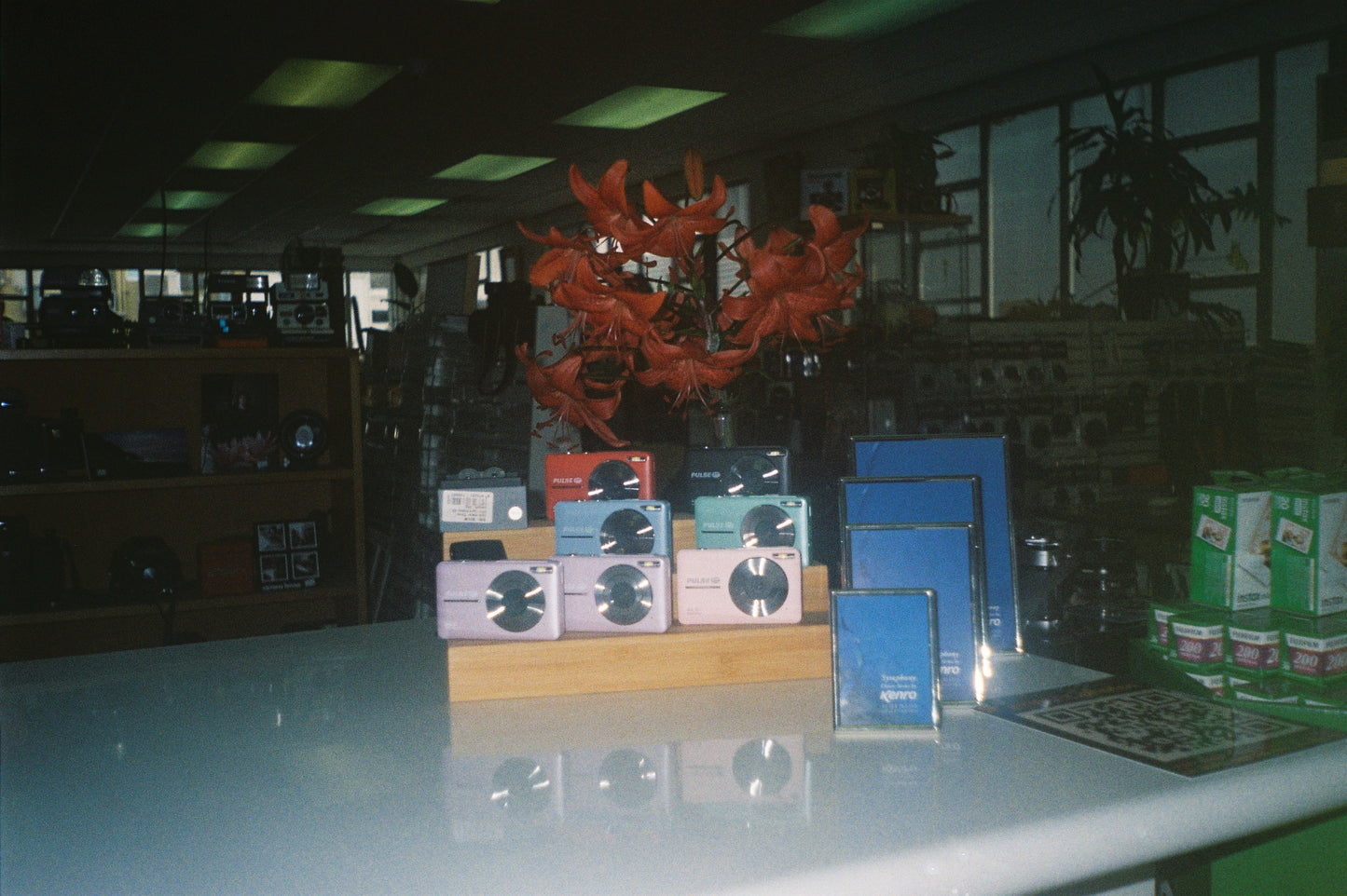 Film photo of a display of boxes and pulse cameras on a table with a dark background
