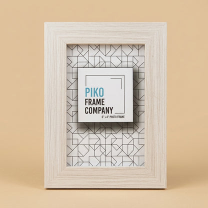 PIKO 6x4 wood photo frame, pale timber finish, standing upright on a beige background