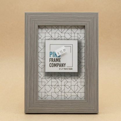 Grey woodgrain PIKO 6x4 photo frame standing upright against a beige background