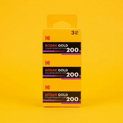 Three-pack of Kodak Gold 200 35mm colour film in yellow carton on yellow background