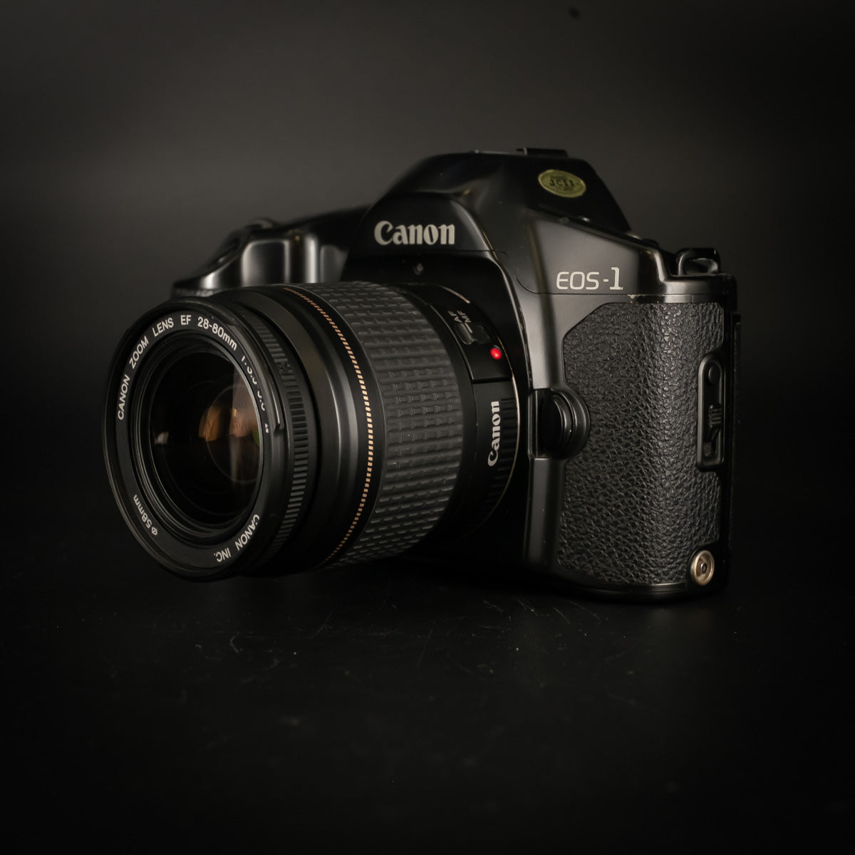 Canon EOS-1 with 28-80mm zoom lens, front three-quarter view on black background