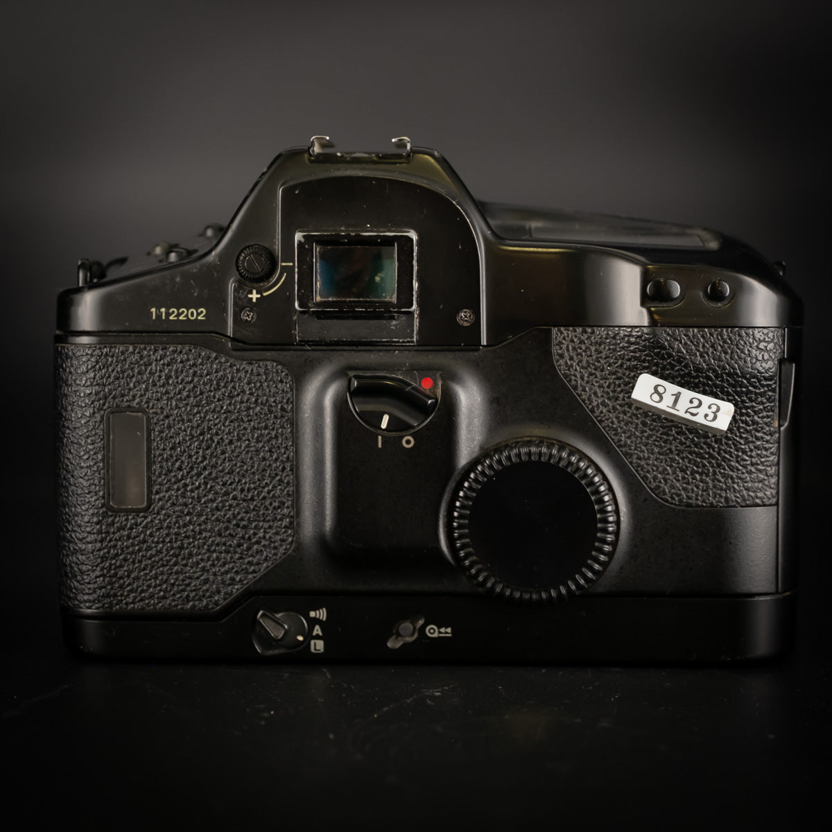 Back of the Canon EOS-1 body showing eyepiece, dial and shop sticker 8123