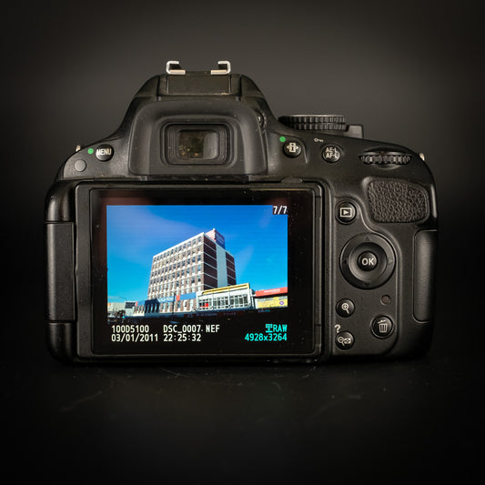 Back of the Nikon D5100 showing a photo of an office building on the screen