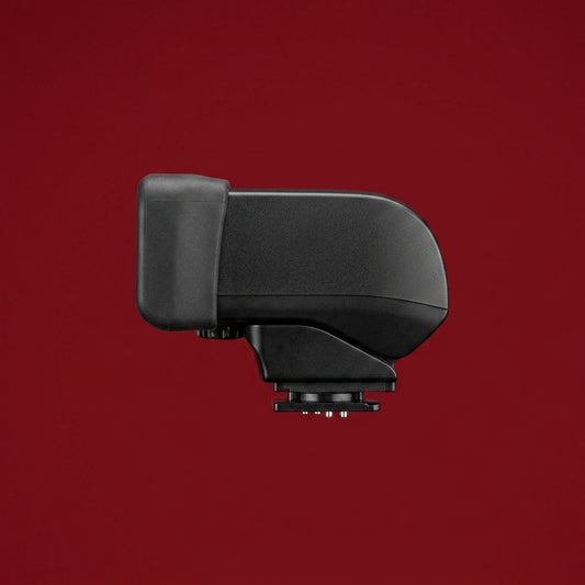 Black Canon EVF-DC1 electronic viewfinder, side view, on a dark red background