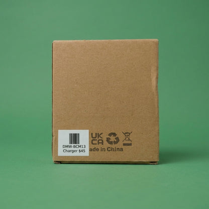 Plain cardboard box labelled DMW-BCM13 Charger, on a green background