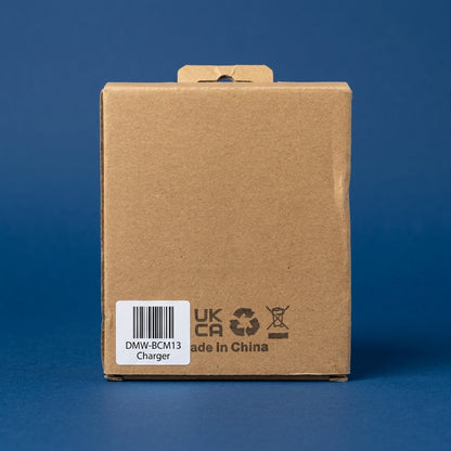 Plain cardboard box labelled DMW-BCM13 Charger, on a dark blue background