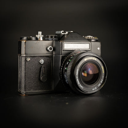 Black Zenit-EM camera with Miranda 28mm f/2.8 lens, front three-quarter view on dark background