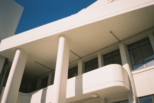 Sample shot: white art deco building with columns and balcony under deep blue sky