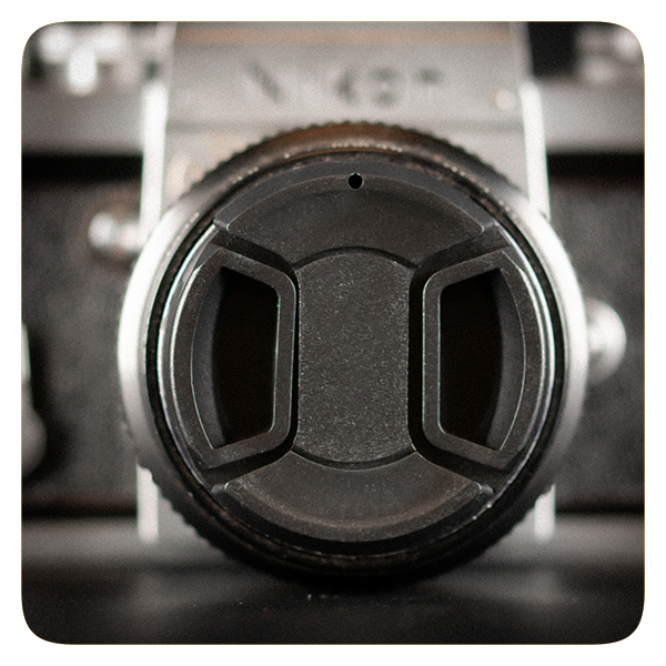 Close-up of a camera lens cap on a blurred background