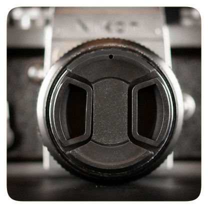 Close-up of a camera lens cap on a blurred background