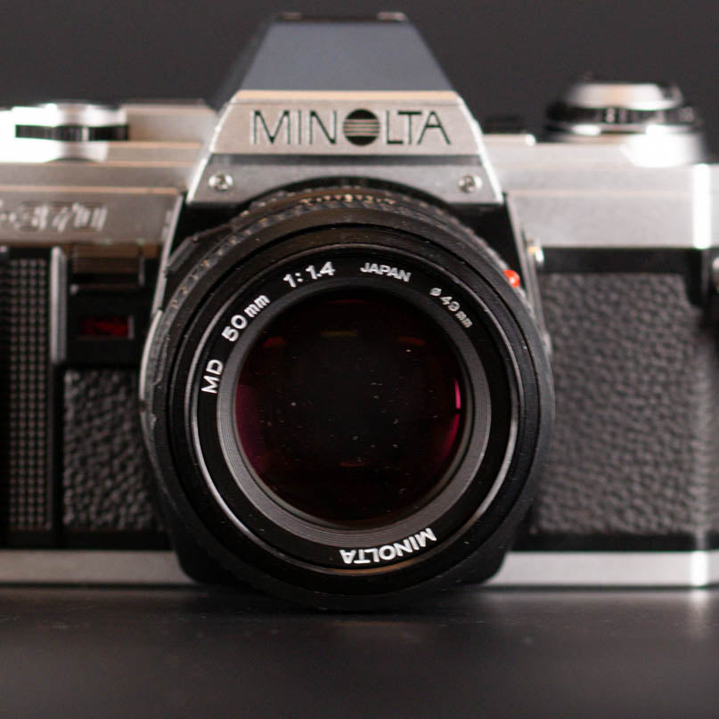 Minolta camera with lens on a dark background