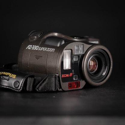 Vintage Olympus Zoom Bridge camera with 'AZ-330 Super Zoom' on a black background