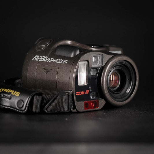 Vintage Olympus Zoom Bridge camera with 'AZ-330 Super Zoom' on a black background