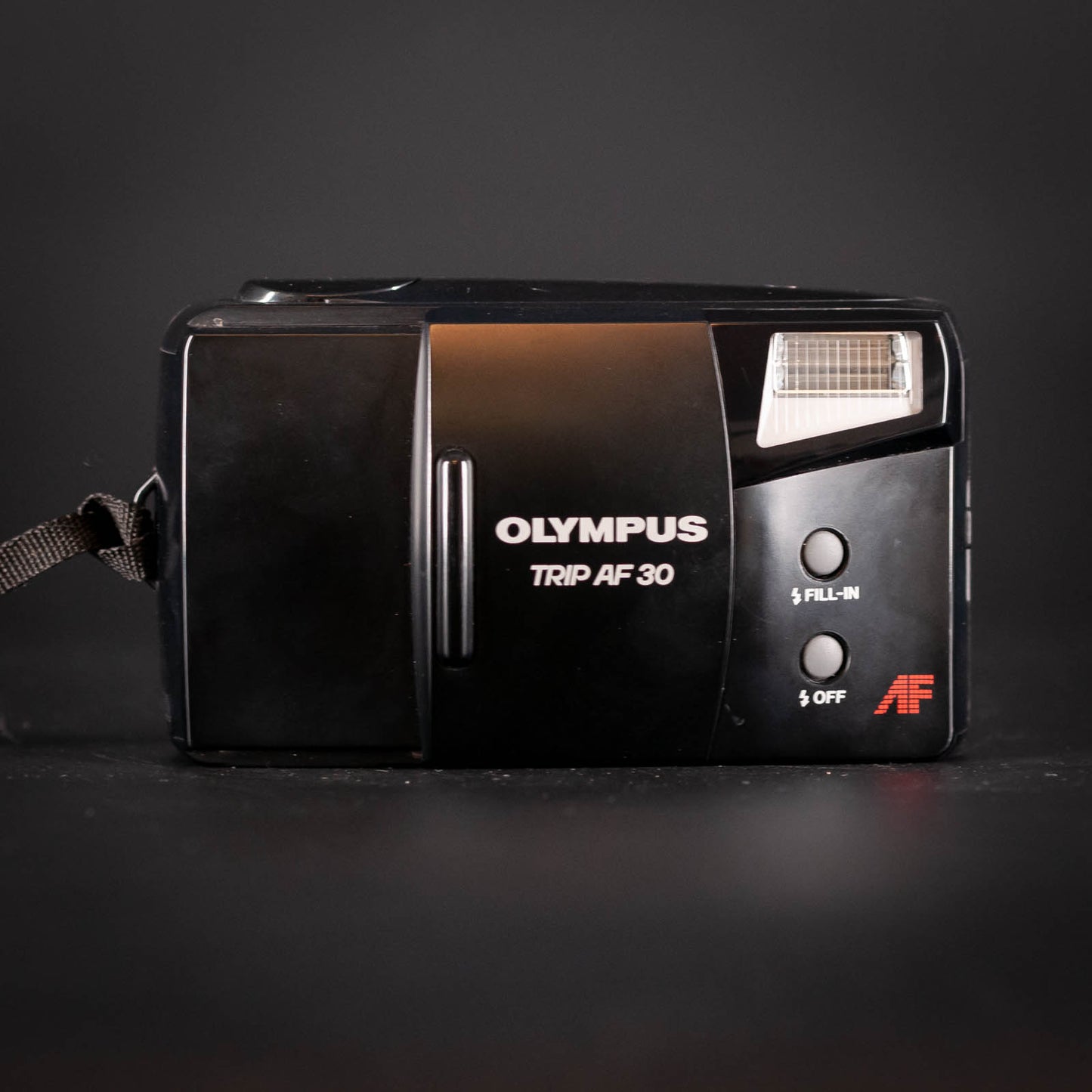 Vintage Olympus Trip AF 30 camera on a dark background