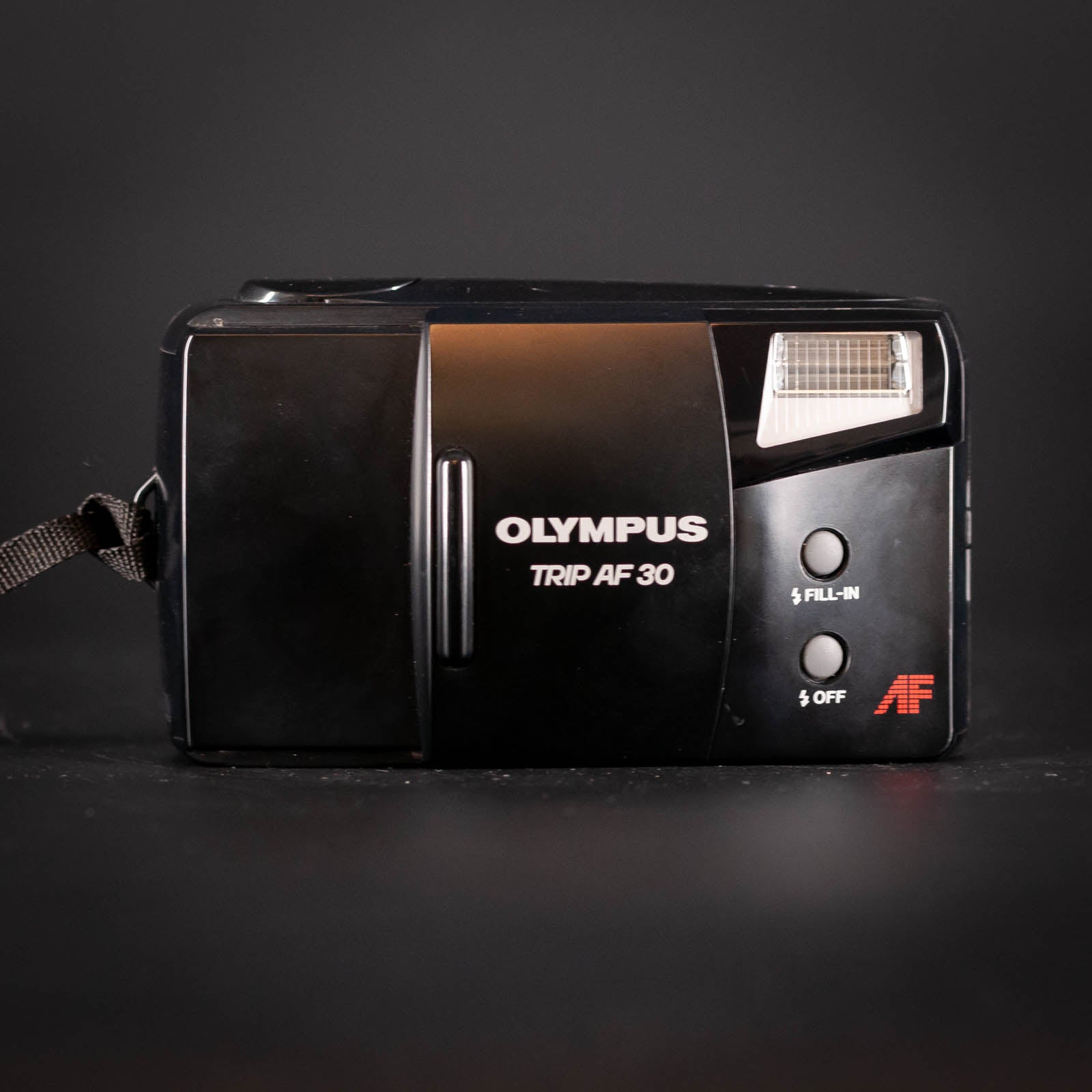 Vintage Olympus Trip AF 30 camera on a dark background