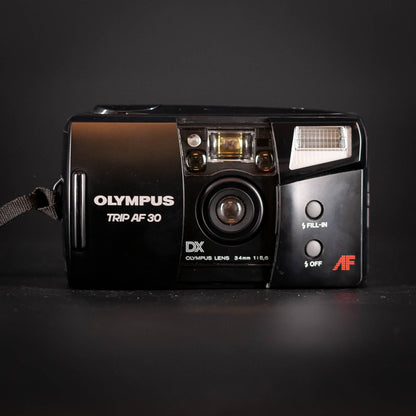Black Olympus camera with visible branding on a dark background