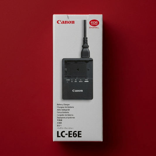 Canon LC-E6E battery charger in its boxed packaging on a red background
